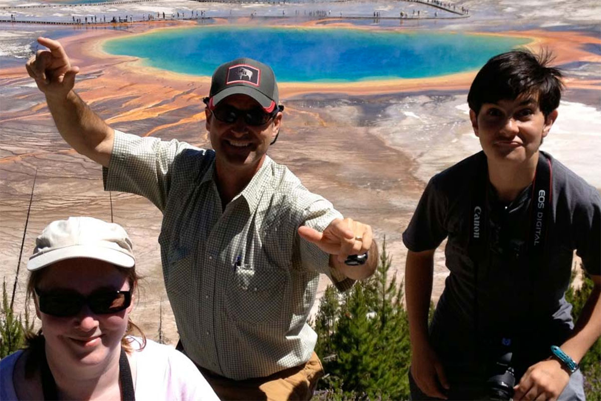 Smiling Private Yellowstone Tour Group in Front of Grand Prismatic Spring - Buffalo Roam Tours