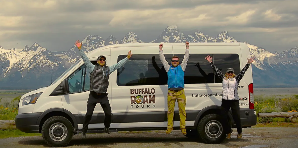 Buffalo Roam Tours guides celebrating in front of the Grand Teton mountains, representing a Grand Teton National Park travel guide experience in Jackson Hole.